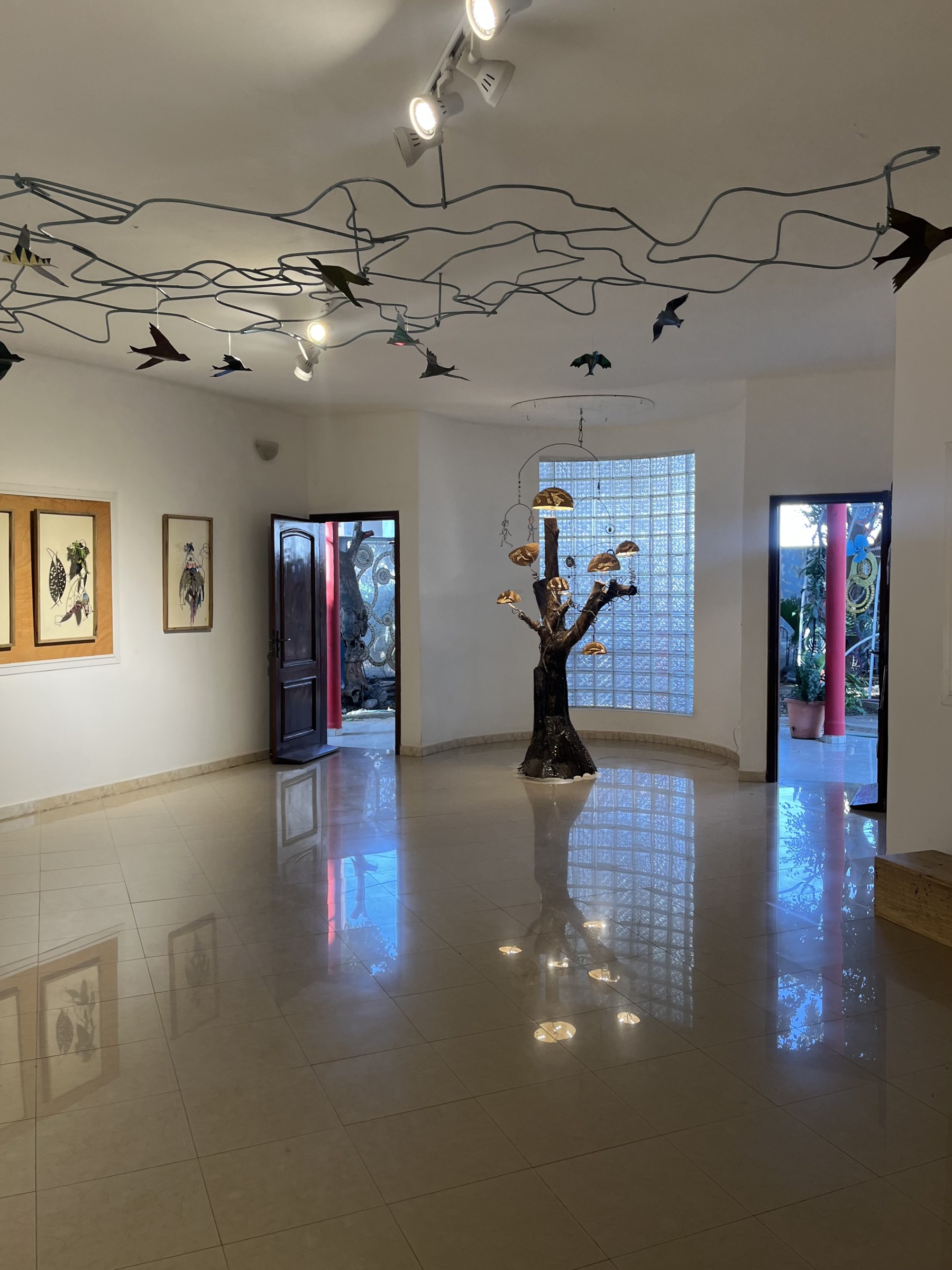 Salle de la galerie avec oiseaux suspendus et sculpture en forme d’arbre